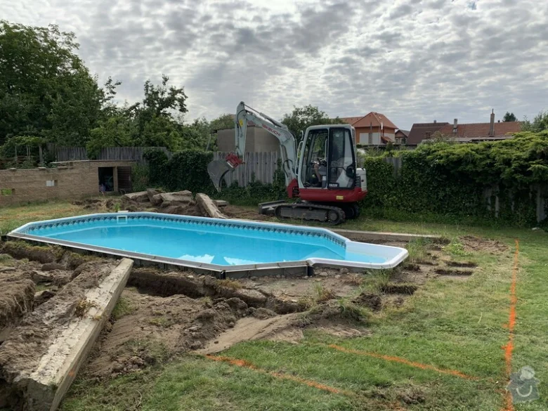 Bazén v zahradě během úpravy terénu s výkopovou technikou.
