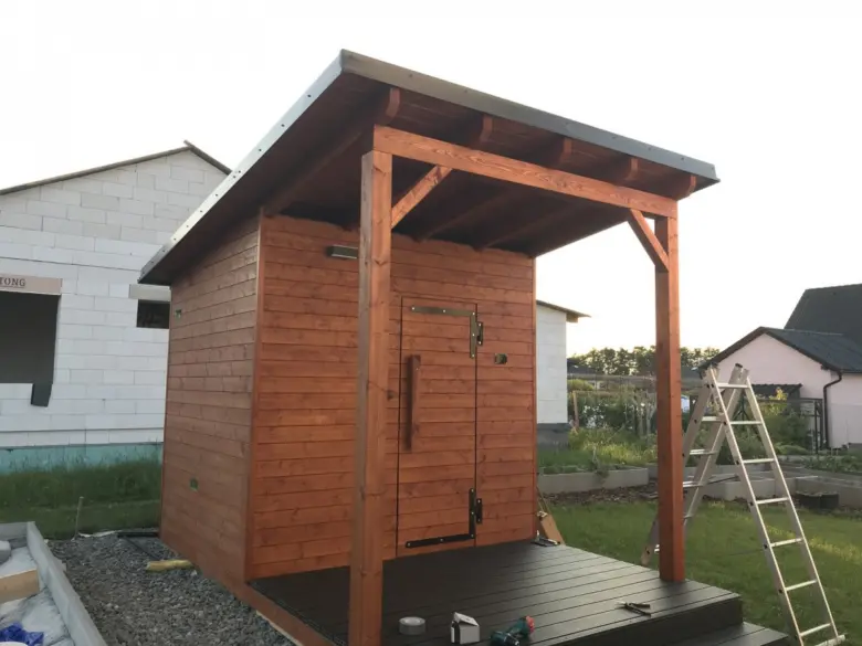 Venkovní dřevěná finská sauna v procesu stavby s terasou.