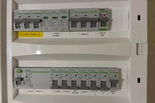 Otevřená rozvaděč s pojistkami pro elektroinstalaci v panelovém bytě.