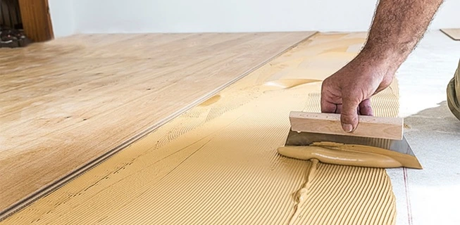 Náplast na podlahu se nanáší špachtlí před pokládkou vinylové podlahy.