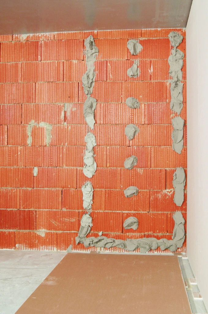 Príprava zdi sádrokartonem na cihlovou zeď pomocí lepidla.