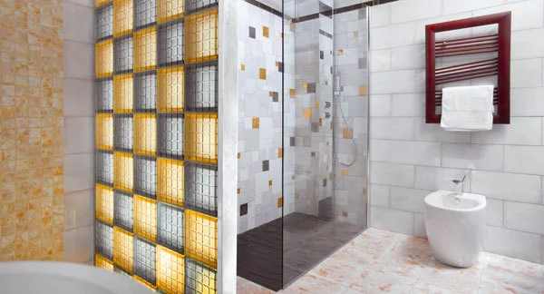 Moderní renovace toalety s skleněnými bloky a bílými dlažbami.