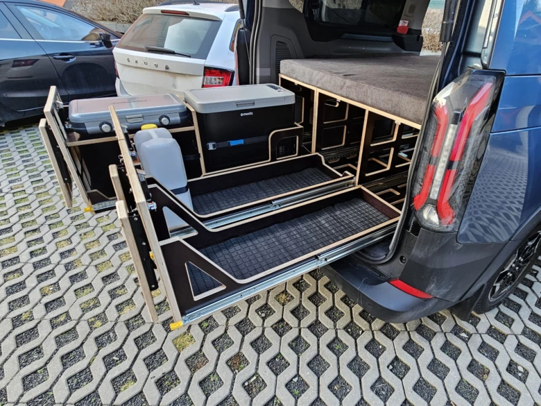 Vlastní vestavba modulu do dodávky s úložnými boxy a sedačkou.