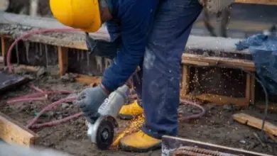 Stavebník řezá ocelovou výztuž pro betonové patky pergoly.