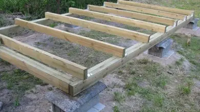 Částečně sestavený dřevěný rám z palet na betonu venku.