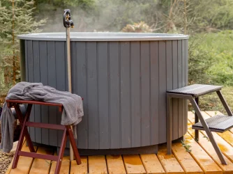 Venkovní finská sauna s horkou vanou na dřevěné terase.