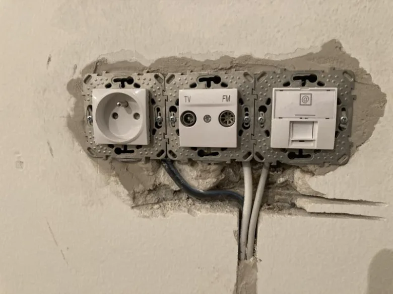 Instalace elektrického zásuvky s televizním připojením v domácnosti.