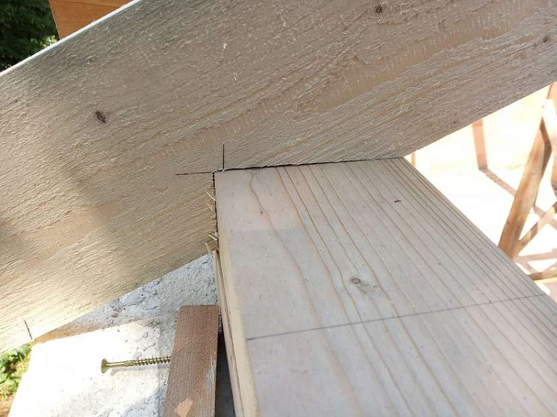 Detail spoje dřevěného krovu s vyznačenými značkami pro řezání.