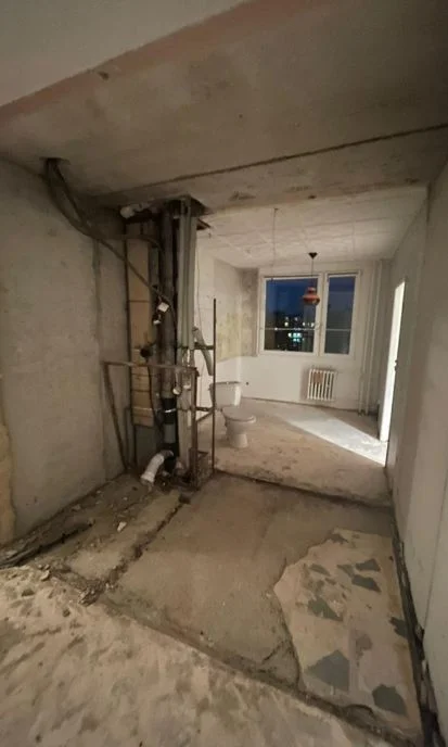 Byt v rekonstrukci s odhalenými instalacemi a zbytky podlah.