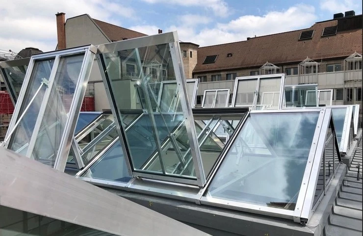 Řada sedlových světlíků nainstalovaných na střeše budovy.