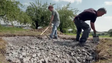 Muži připravují štěrkovou vrstvu pro betonáž základů domu.