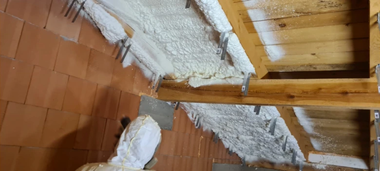 Stříkaná izolace se nanáší mezi dřevěné trámy.