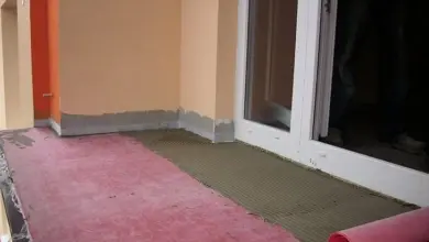 Práce na izolaci balkonu s rozebraným podlahovým krytem.