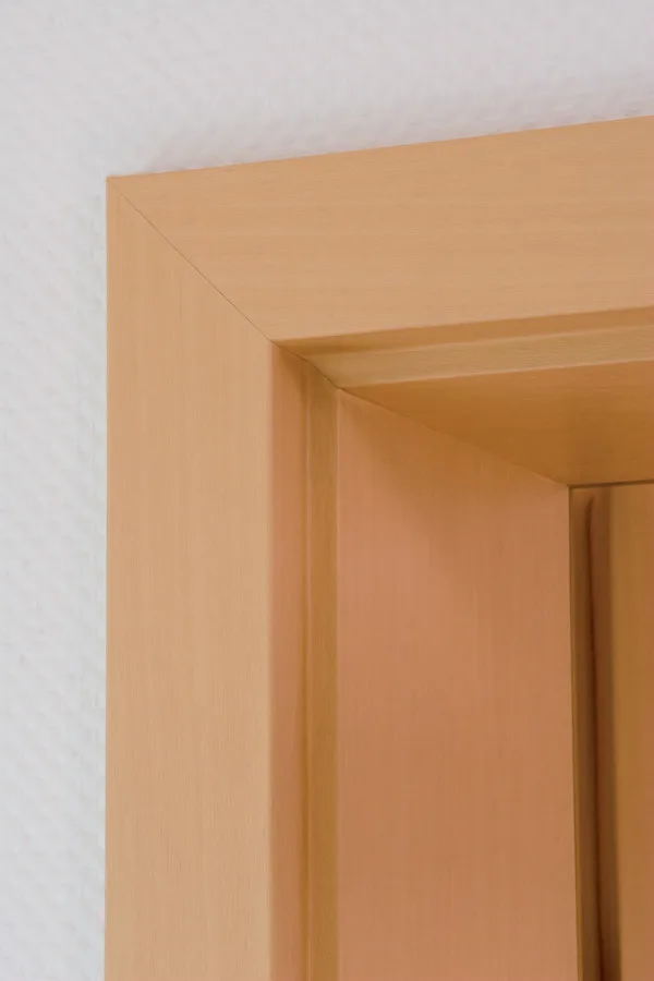 Detail dřevěného zárubně s rohovým spojem u dveří.