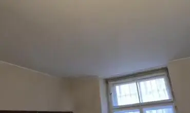 Přestavba starého sklepa s odhalenými zdi a oknem.
