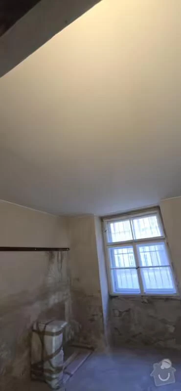 Přestavba starého sklepa s odhalenými zdi a oknem.