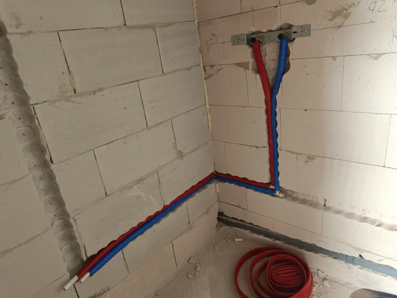 Instalace topných potrubí ve zdi svépomocí s červenými a modrými hadicemi