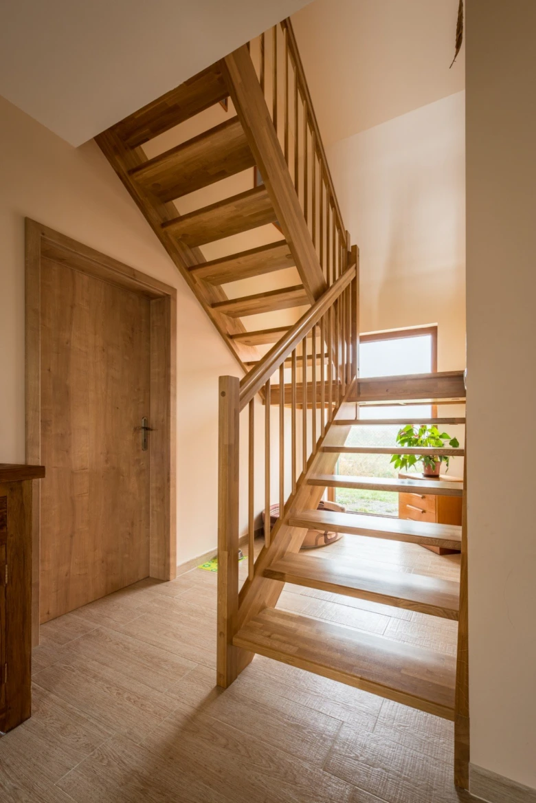 Moderní dřevěné schodiště v interiéru s přírodním designem.