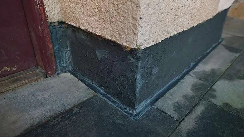 Detailní pohled na hydroizolaci základů a soklu domu.