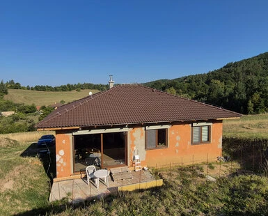 Dům na svahu s nakloněnou střechou pro výpočet sklonu v procentech.