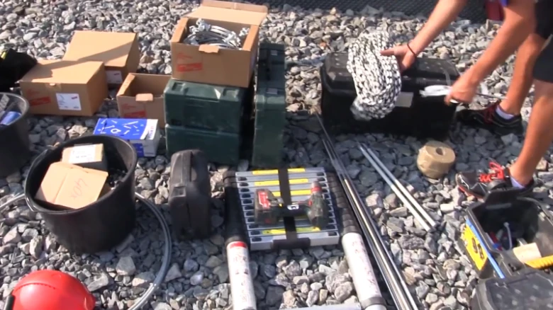 Nástroje a materiály pro montáž hromosvodu na kamenné ploše.