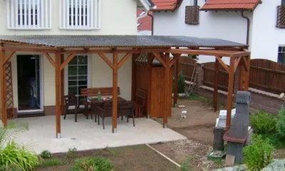 Pergola s střechou v zahradě domu.