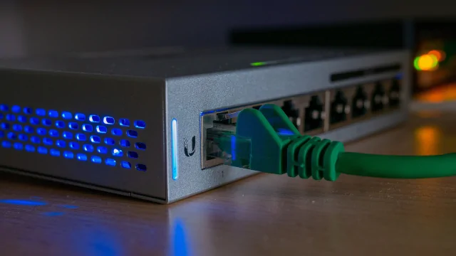 Zelený síťový kabel je zapojen do portu na přepínači pro přístup k internetu.