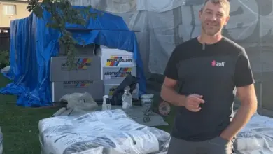 Muž stojí vedle baleného polystyrénu pro izolaci fasády.