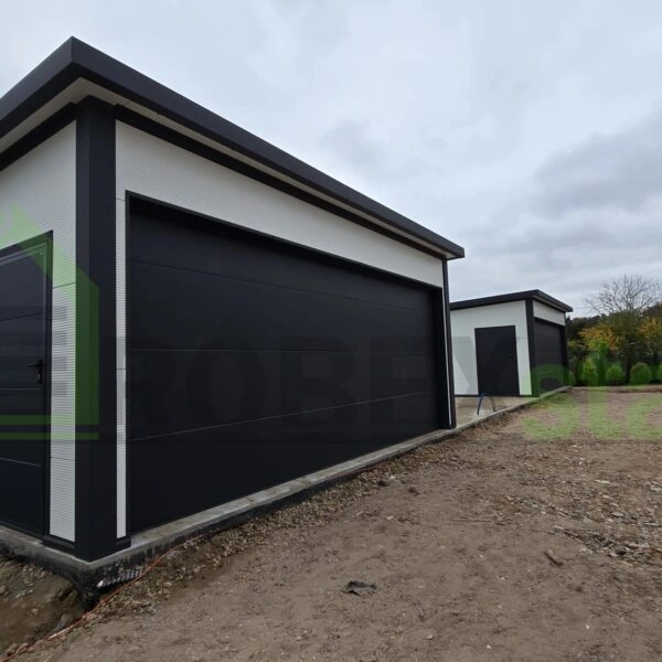 Moderní montovaná garáž z PUR panelů s černou bránou.