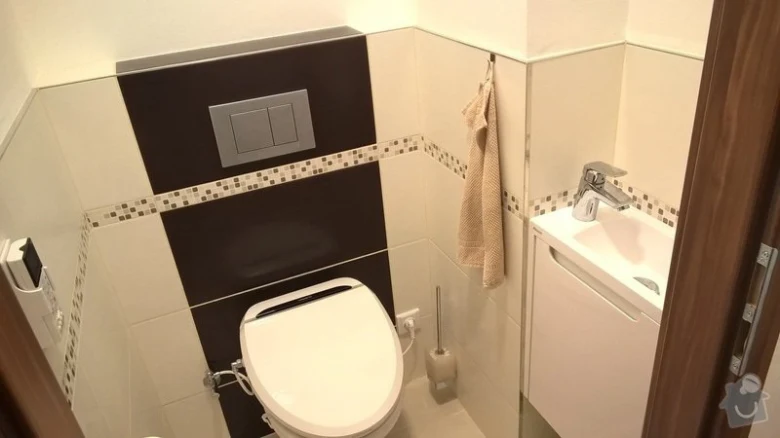 Moderní renovace malého toaletu s bílými dlaždicemi a tmavým akcentem.