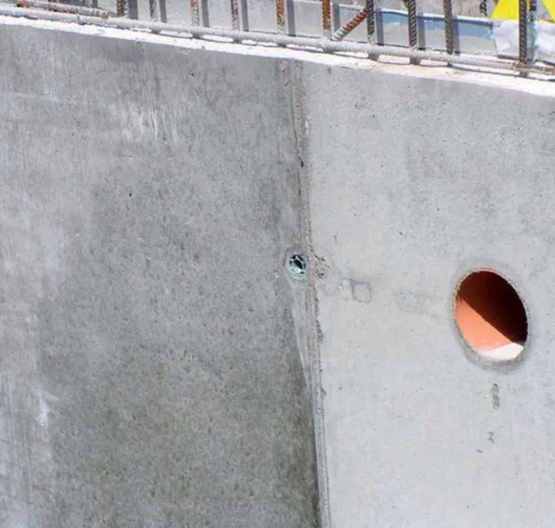 Pohledový beton s otvory v zdi po odlití.
