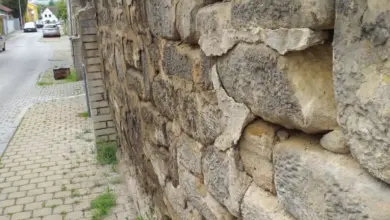 Kamenná opěrná zeď vedle chodníku v obci