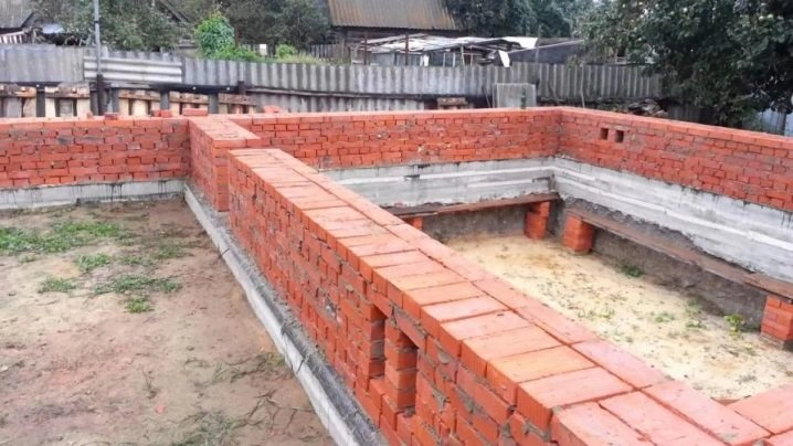 Červené cihlové zdi v stavbě ukazují rozměry cihel na místě.